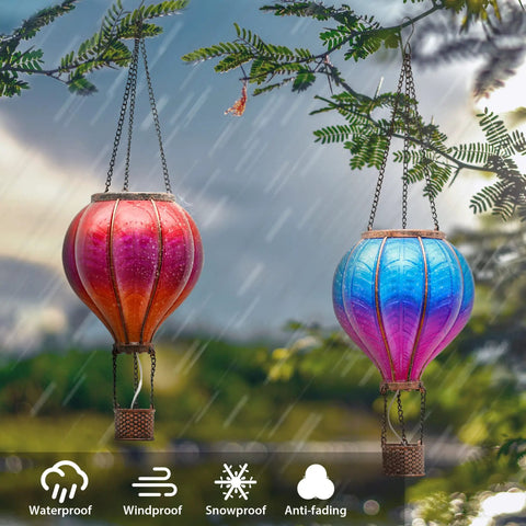 Set Of 2 Dope Hot Air Balloon Solar Lanterns For Outdoor Garden Decor glowing in rain, hanging among tree branches