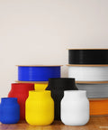 Front view of assorted PETG 1.75mm 3D printer filament spools in blue, yellow, red, black, white on a wooden table.