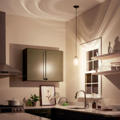 Kitchen scene with Brinley 7.75 Inch Kitchen Pendant In Olde Bronze With Clear Glass over sink illuminating counter area.