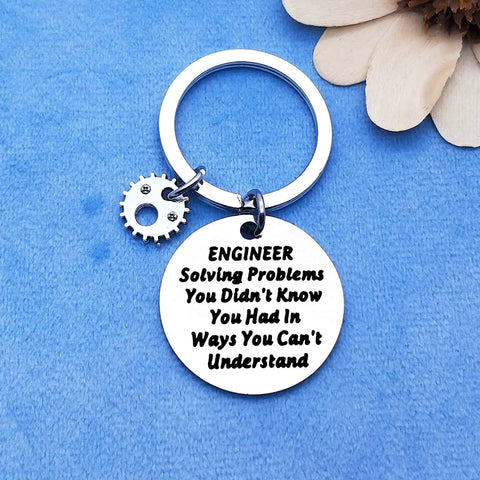 Stainless steel keychain with "Engineer Solving Problems You Didn't Know You Had" engraving on a blue background.