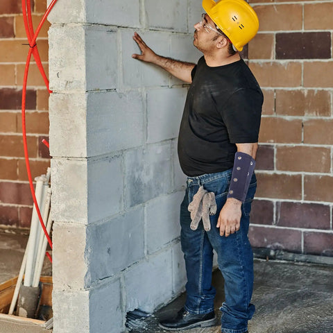 Lightweight Cut Resistant Wrist Guards With Breathable Mesh Sleeves For Mechanics And Yard Work on a worker inspecting a wall.
