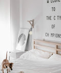 Bedroom scene with Edison G30 Globe Vanity Light Bulb 60W on wall above bed, cozy decor and dog playing on white bedding.