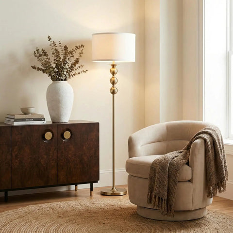 Riley 60 Inch Floor Lamp With Drum Shade In Gold Brass Finish For Living Room Or Bedroom Modern Standing Lamp With Boho Chic Mid Century Vibe And Elegant Corner Light For Office next to armchair and cabinet