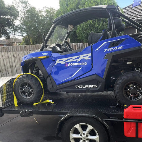 Beefed Up Heavy Duty Wheel Chock Tie Down Kit With 4500 Lb Break Strength, securing a blue ATV on a trailer.