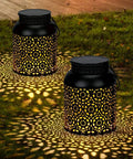 Outdoor Solar Lanterns Pack of 2 Waterproof Hanging Lanterns With Handles creating intricate light patterns on grass.