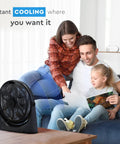 Family sitting on sofa near 20 Inch High Velocity Floor Fan With Wall Mount And 180 Degree Tilt, enjoying air circulation.