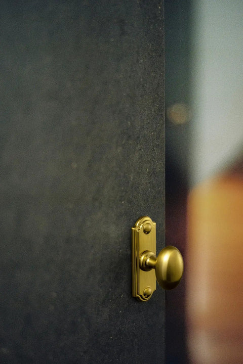 Brushed Gold Oval Cabinet Knobs Mounted On Square Backplates, Killer Hardware For Cupboards And Dressers, Anti Corrosion Finish That Is Slick And Durable, Total Game Changer, 6 Pack on a dark door.