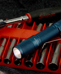 Blue Quark LED Flashlight Pocket EDC With Clip on tool rack with socket set, showcasing high CRI beam and compact design