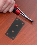 Installing Stainless Steel Corner Brace Plates Set For Wood Shelves with screwdriver, sleek black finish visible on table