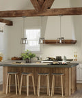 Coastal 1-Light Mini Pendant in Antique Bronze for Rustic Farmhouse Vibe hanging over kitchen island with stools