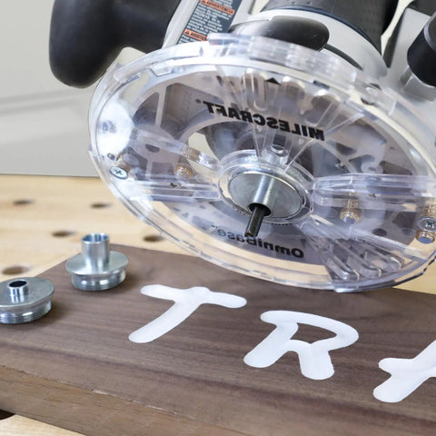 Universal 7 Inch Router Base Plate With Adjustable Swivel Wings And Clear Top For Sharp Vision shown on a wooden surface with centering pins.