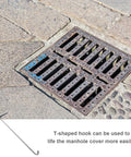Heavy Duty Manhole Cover Hook With T Shaped Handle 15 Inch Pull Tool beside a sewer cover on stone pavement