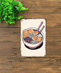 Vintage Ramen Bowl Metal Sign Tin Wall Art 8x12 Inches Japanese Style Kitchen Decor on wooden surface with green plant