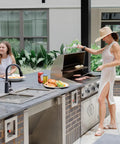 Outdoor patio with a Powerful 18-Inch High-Velocity Heavy-Duty Industrial-Grade Floor Fan cooling a grilling area, people present