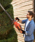 Man using red hedge trimmer with Heavy Duty Impact Gloves For Men And Women, TPR Knuckle Guards, Cut Resistant Nitrile Grip