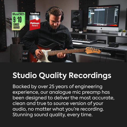 Musician recording with guitar in studio featuring EVO 4 USB Audio Interface Dope Studio Gear With SmartGain Auto Dial DSP Low Latency Mixer And Flexible Routing Matrix Discrete JFET Instrument Input Rotary Dial With LED Ring AKM AD DA Converters Compact USB Audio Pro, surrounded by audio equipment and computer screen displaying audio software interface.