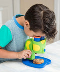 Rad Microscope For Curious Kids Ages 3 And Up A Hands On Science Toy That Sparks Discovery Of The Tiny World With Easy Focus Lenses And Colorful Slides For Fun Safe Kid Friendly Learning. Child using green plastic microscope with cookie slide