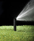 Pressure Regulating Dual Spray Pop Up Sprinkler With 90 Degree Quarter Circle Pattern And 8 To 15 Foot Spray Distance, 4 Inch Pop Up Height, Water Saving Regulator Delivers Constant 30 PSI For Consistent Irrigation spraying water on grass