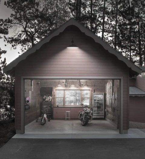 Outdoor Gooseneck Barn Light Fixture 14 Inch With Dusk To Dawn Sensor illuminates a garage exterior at night.
