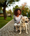 Weather Resistant Green Steel Dog Waste Station With 13.5 Gallon Capacity Outdoor Poop Trash Can For Parks Trails And Public Areas Built From Galvanized Steel With Rugged Powder Coat Finish That Keeps It Looking Sharp on a park path with a woman and dog nearby.