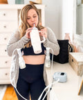 Woman using Powerhouse Rechargeable Cordless Breast Pump With Hospital Strength Suction and Dual Adjustable Settings while drinking.