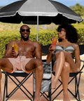 Two Person Folding Camping Chair With Adjustable Umbrella Built In Cooler at the beach with two people enjoying drinks