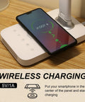LED Desk Lamp With Wireless Charging And USB Port, smartphone charging on lamp base, touch control visible, wood desk surface