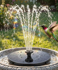 Solar Fountain Kit For Bird Bath And Ponds With 1.4W Pump, 7 Nozzles, And 4 Fixed Pipes in garden setting.