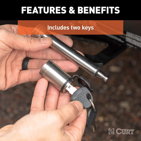 Person holding a stainless steel trailer hitch lock with five-eighth inch pin diameter, includes two keys.