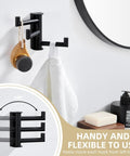 Super Slick Swivel Towel Hook With Three Turning Arms Matte Black Wall Mount Coat Rack displaying towel and wooden brush