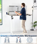 Upgrade Your Workspace With This Slick Dark Gray Standing Desk Measuring Sixty-Three By Thirty-Two Inches, shown in use with dual monitors.