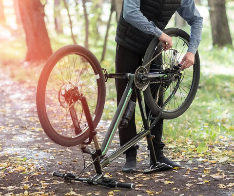 Person adjusting 6/7/8 Speed Bike Chain for Road and Mountain Bikes, Pro Grade Performance, outdoors with fallen leaves.