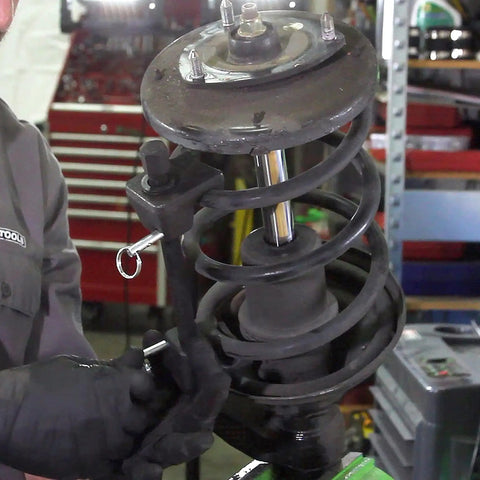 Mechanic using MacPherson Strut Spring Compressor Kit Two Pack With 10.75 Inch Opening Universal Automotive Tool in workshop