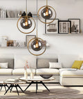 Living room with Industrial Vintage 3 Light Pendant Lighting Fixture With Brass Ring And Glass Globe Shades In Amber Clear And Gray