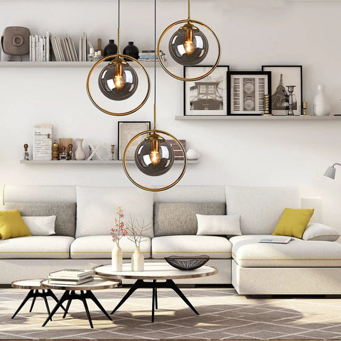 Living room with Industrial Vintage 3 Light Pendant Lighting Fixture With Brass Ring And Glass Globe Shades In Amber Clear And Gray