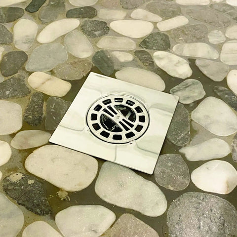 Square Shower Drain Hair Catcher Works Like A Charm By Trapping Every Stray Hair Before It Gets Into Trouble Smooth Chrome Finish installed on pebble floor.