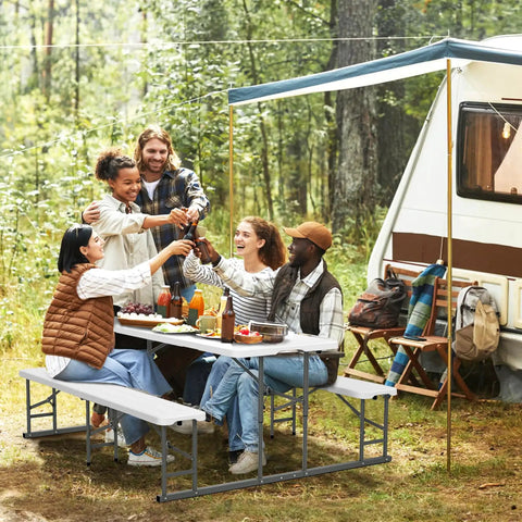 Group enjoying a meal at a Folding Picnic Table And Bench Set With Wood Grain Plastic Top And Sturdy Metal Frame, by a camper.