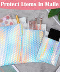 60 Pack Holographic Bubble Mailers Dope Waterproof Self Seal Foil Glitter Glamour Shipping Envelopes In 3 Sizes shown with makeup and phone