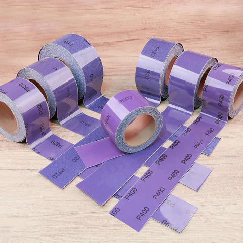 Top Tier PSA Purple Ceramic Sandpaper Roll For Longboard And Auto Detailing Jobs With 180 Grit Precision Grip Self Stick Adhesive Backing Peel Off Liner Easy Cut To Size Durable Wood Metal Sanding Experience displayed on a wood surface.