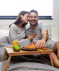 Couple enjoying breakfast in bed on Heavy Duty Queen Bed Frame Rocking Piano Key Headboard And Reliable Metal Platform Base.