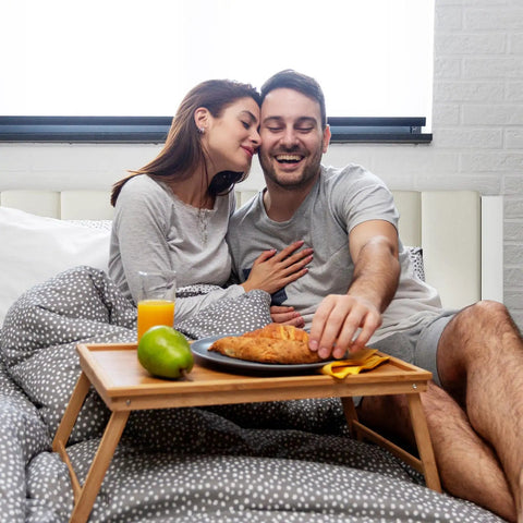 Couple enjoying breakfast in bed on Heavy Duty Queen Bed Frame Rocking Piano Key Headboard And Reliable Metal Platform Base.