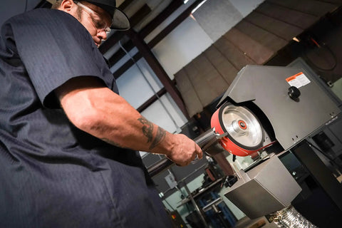 Person using Heavy Duty 2 By 72 Square Belt Grinder Featuring Slick Variable Speed Drive for metal shaping.