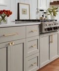 Champagne Bronze Traditional Cabinet Pull For Cabinets And Furniture Five And One Sixteenth Inch Center To Center Mounting Six And One Half Inch Overall Length Durable Drawer Handle One Pack Classic Hardware For Kitchen Or Bath installed on gray kitchen cabinets.