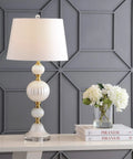Pearl White Fluted Glass LED Table Lamp 30 Inch with Stacked Sphere Crystal Base White Faux Silk Shade next to flowers.