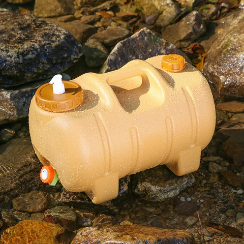 Camping Water Container With Spigot And Soap Dispenser Portable Water Storage Jug in yellow on rocky terrain.
