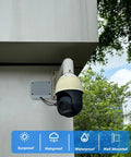 Security camera mounted on outdoor wall with sunproof, rainproof, and waterproof labels, trees in the background.