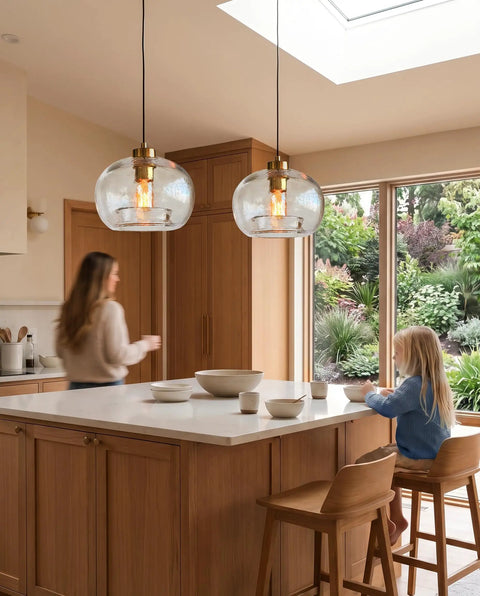 CASAMOTION Glass Pendant Lights, Textured Clear Globe Shade hanging over a kitchen island with a woman and child.