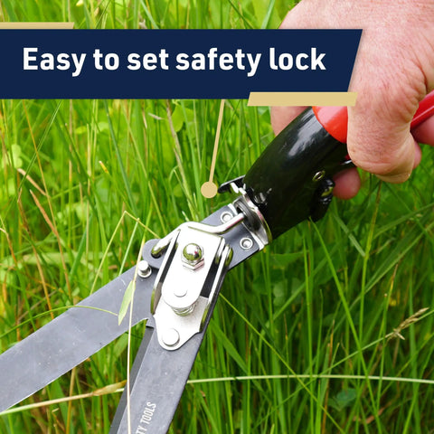 Hand using Rotating Handle Grass Shears For Precision Edging And Hedge Trimming with easy-to-set safety lock in garden use.