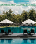 Heavy Duty Patio Umbrella Base With Wheels For Outdoor Square Market Stand by the pool with chairs and trees in background.
