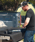 Man using Pin Punch Set 40 Piece Steel And Brass With Hammer And Bench Block for mechanical repair on truck tailgate outdoors.